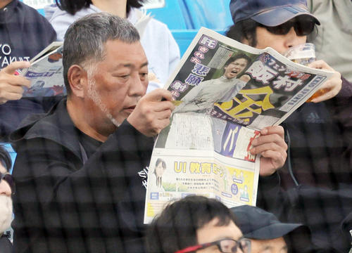 早大対慶大　慶応スポーツを読みながら観戦する清原和博氏（撮影・野上伸悟）