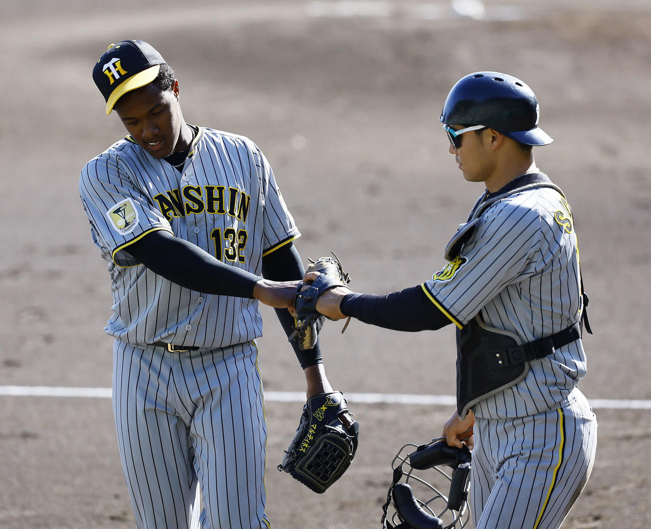 紅白戦で2回無失点で投げ終え、栄枝（右）とタッチを交わす紅組マルティネス（撮影・藤尾明華）