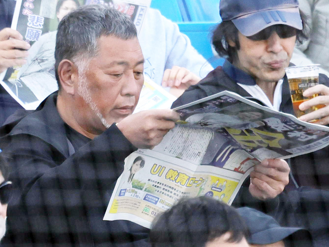 早大対慶大　慶応スポーツを読みながら観戦する清原和博氏（撮影・野上伸悟）