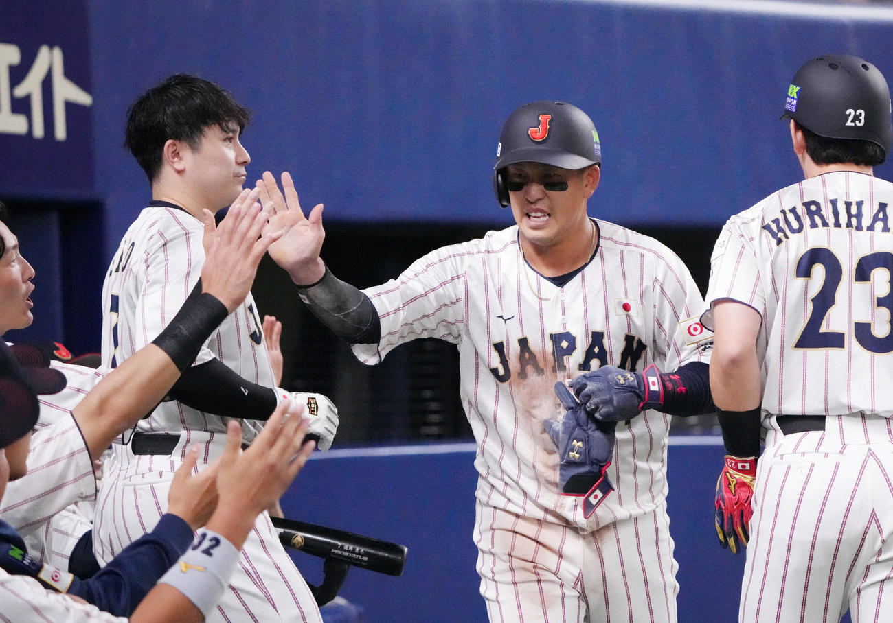 日本対チェコ　6回裏日本1死満塁、小園（中央）は栗原の左犠飛で生還しナインとタッチを交わす（撮影・森本幸一）