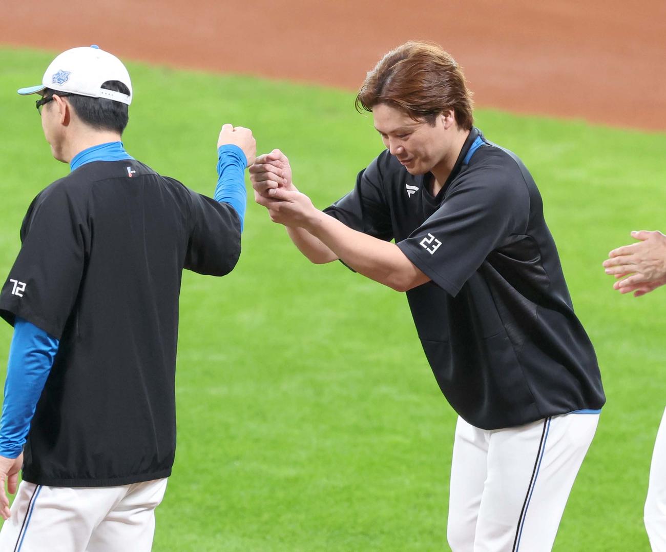 秋季キャンプを打ち上げ山田バッテリーコーチとタッチする日本ハム伏見（撮影・黒川智章）