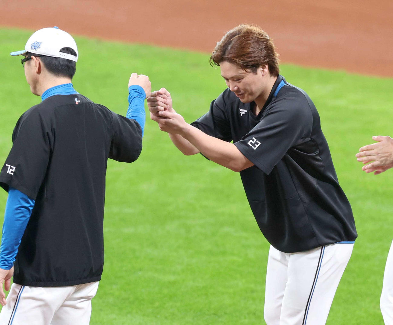 秋季キャンプを打ち上げ山田バッテリーコーチとタッチする日本ハム伏見（撮影・黒川智章）
