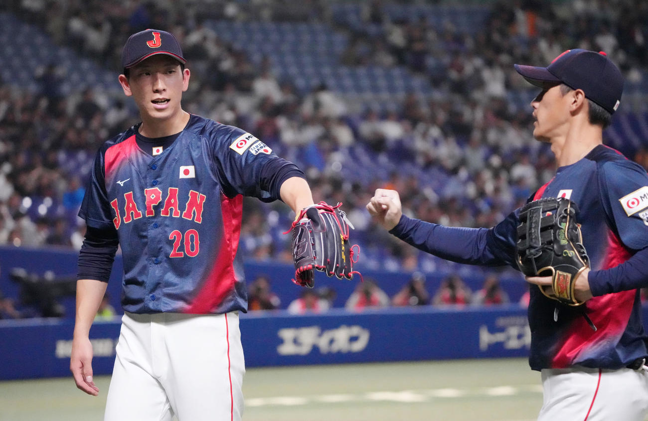 日本対チェコ　4回終了、ナインとタッチを交わしベンチへ戻る戸郷（左）（撮影・森本幸一）