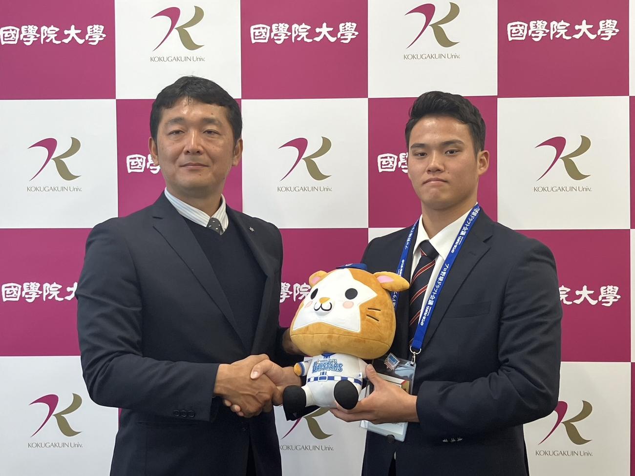 指名あいさつを受け、木塚スカウトと写真に納まるDeNAドラフト6位の国学院大・坂口翔颯（撮影・久保賢吾）