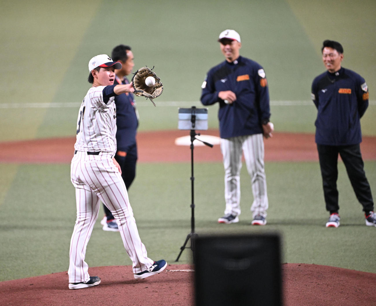 井端監督（右奥）と吉見コーチの見守る中、マウンドから投げる井上（撮影・和賀正仁）