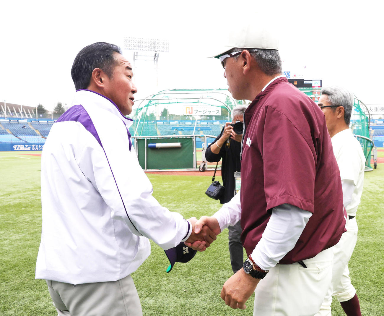 試合前にあいさつを交わす明大・田中監督（左）と早大・小宮山監督（撮影・野上伸悟）