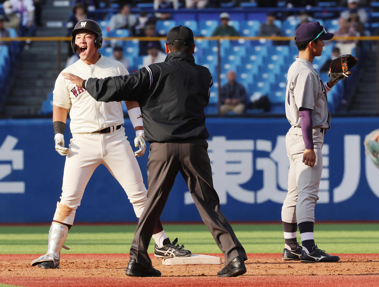 明大対早大　5回裏早大1死、右二塁打を放ち喜ぶ吉納。右は明大・宗山（撮影・野上伸悟）