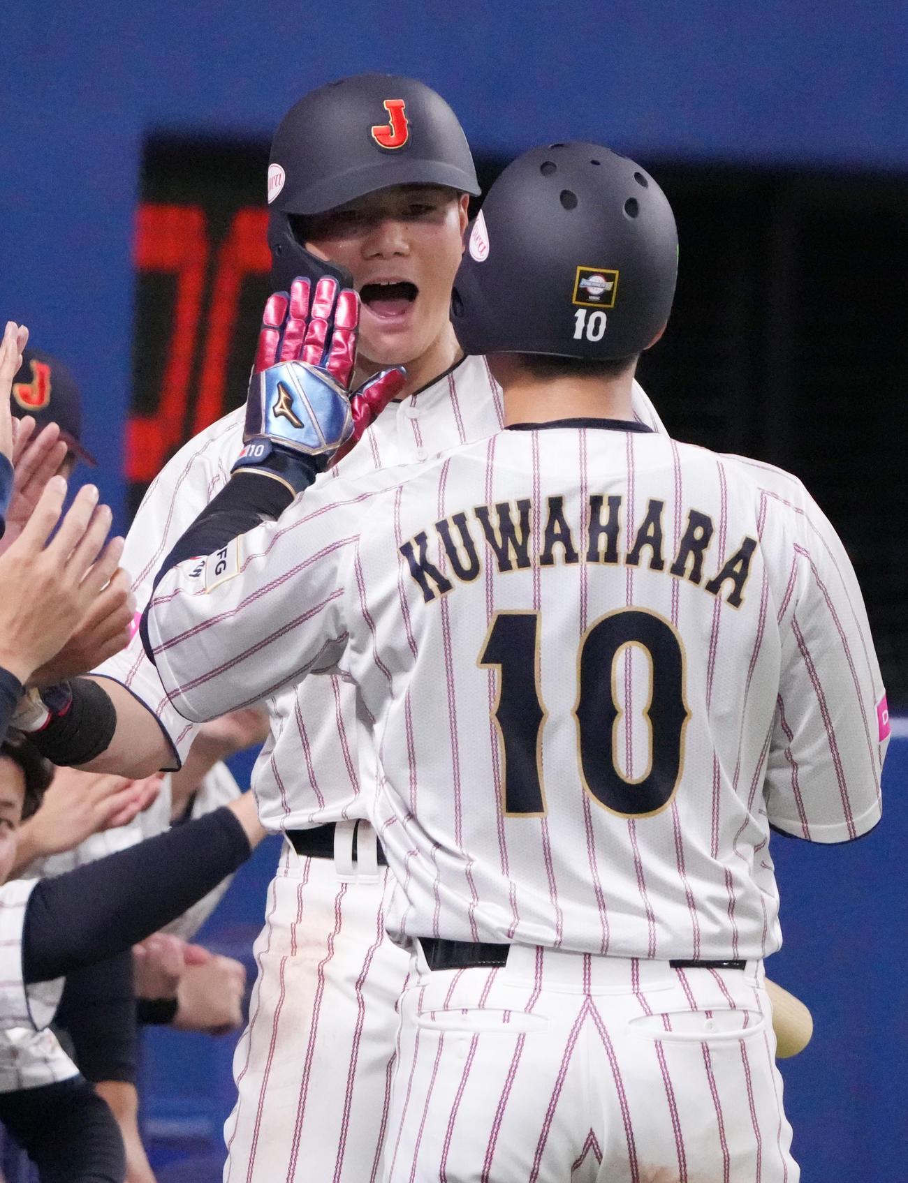 日本対オーストラリア　2回裏日本1死満塁、小園の一ゴロの間に生還しナインとタッチを交わす清宮（右から2人目）（撮影・森本幸一）