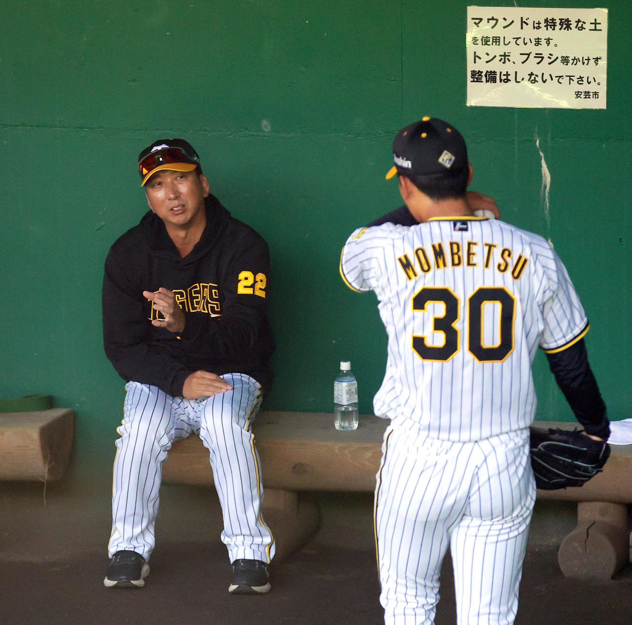 ブルペンで投球する阪神門別（手前）にアドバイスする阪神藤川監督（撮影・上山淳一）