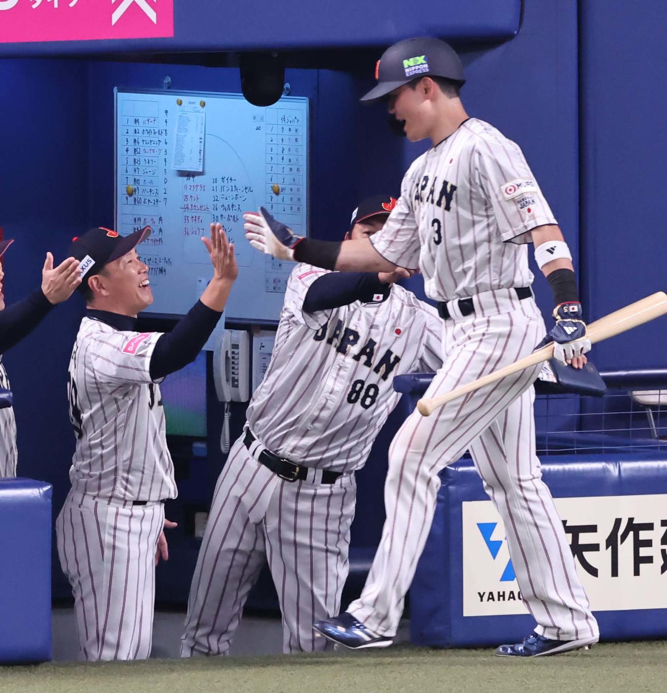 日本対オーストラリア　2回裏日本1死満塁、井端監督（左）は小園の一ゴロで生還した清宮とハイタッチする（撮影・上田博志）
