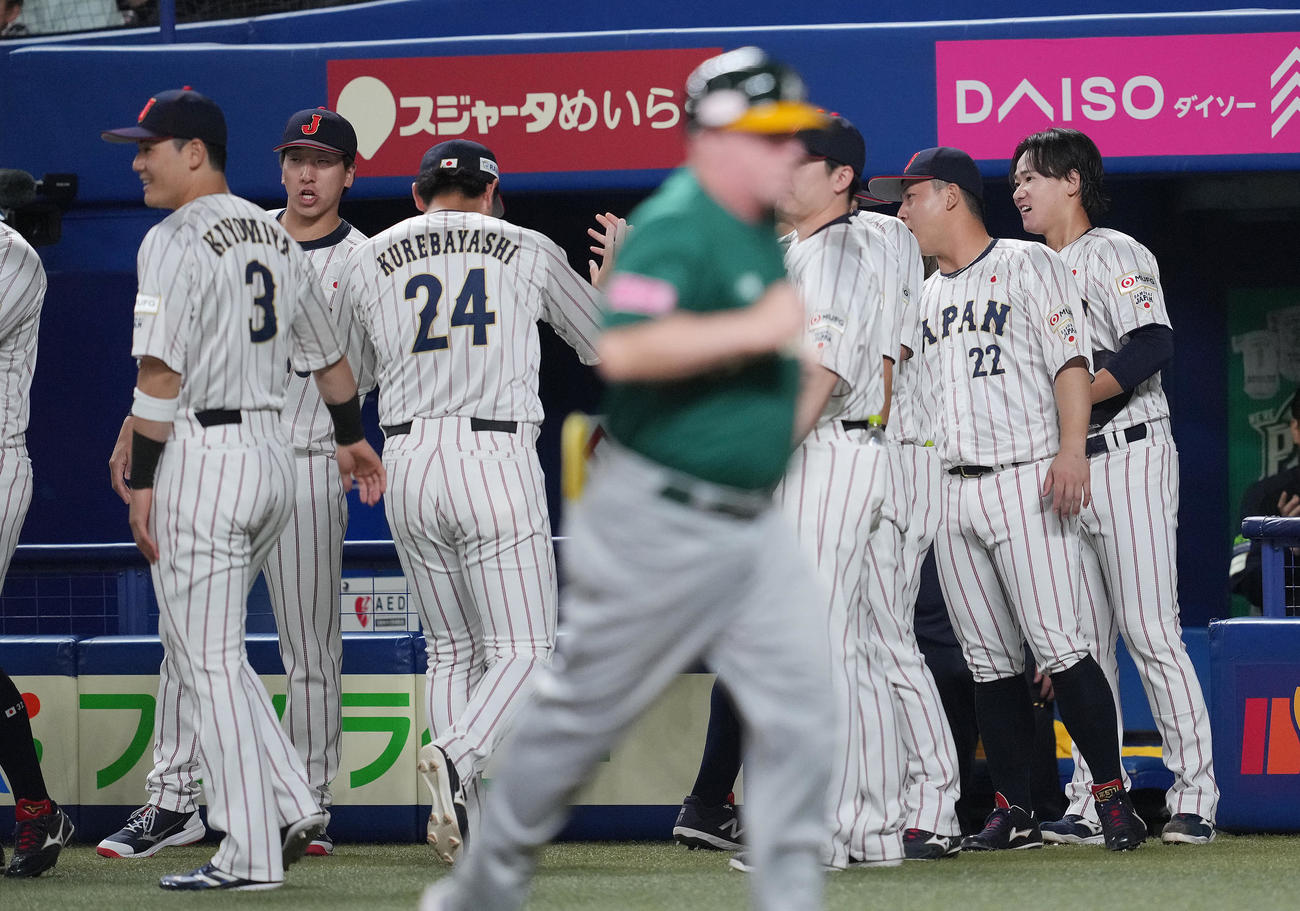日本対オーストラリア　1回表オーストラリアの攻撃を無失点に抑えた井上（右）は好守の紅林（24番）らナインを笑顔で迎える（撮影・垰建太）