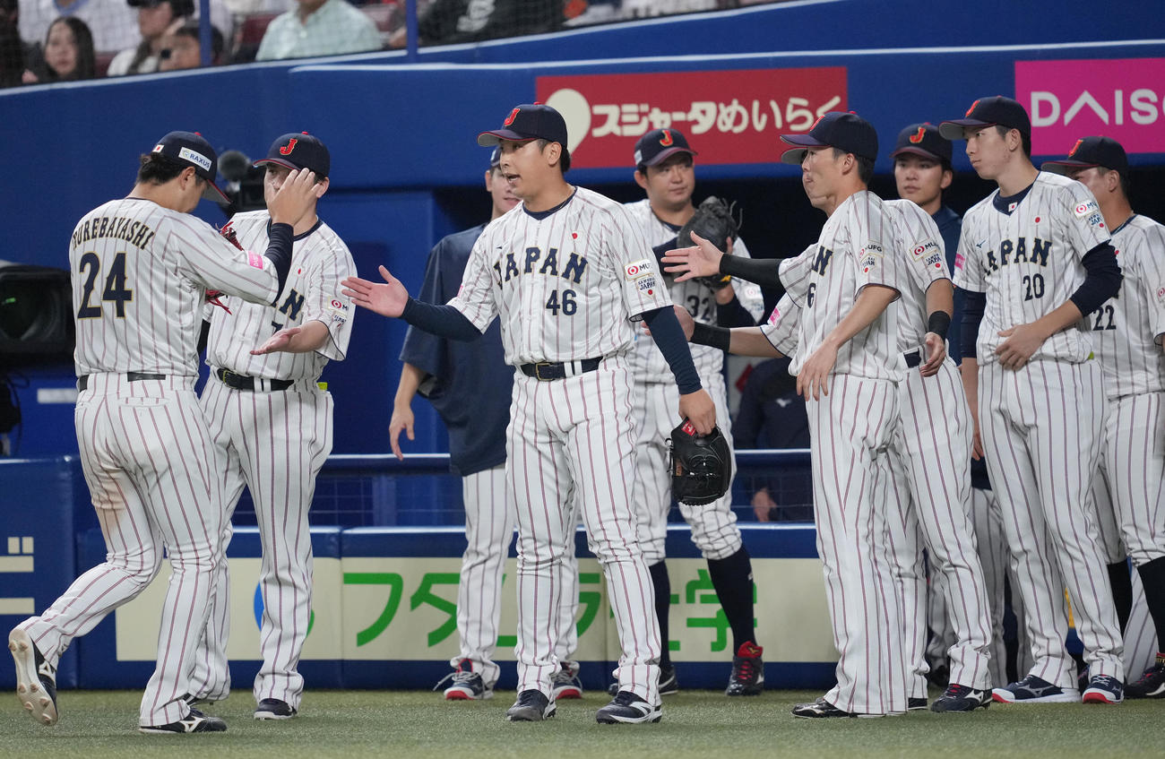 日本対オーストラリア　7回表オーストラリアの攻撃を無失点に抑えナインをタッチで迎える日本藤平（中央）（撮影・垰建太）