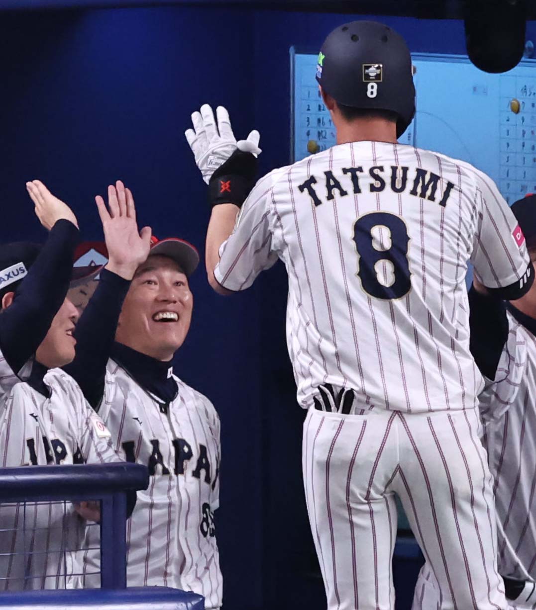 日本対オーストラリア　1回裏日本無死一、三塁、先制犠飛を放った辰己（右）と笑顔でハイタッチをする井端監督（撮影・上田博志）