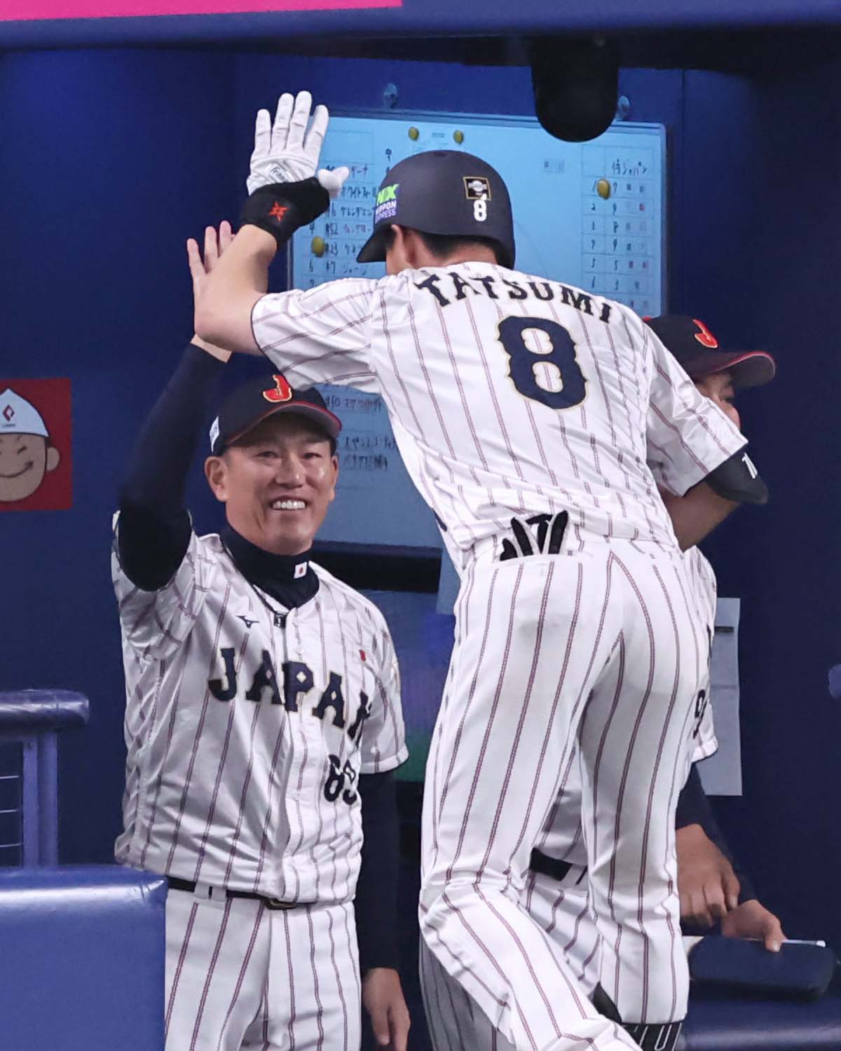 日本対オーストラリア　1回裏日本無死一、三塁、先制犠飛を放った辰己（右）と笑顔でハイタッチをする井端監督（撮影・上田博志）