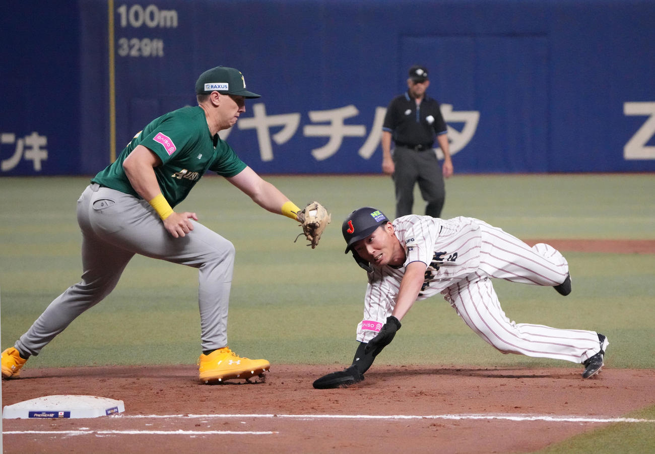 日本対オーストラリア　7回裏日本1死一塁、けん制で飛び出すもタッチを交わし一塁セーフの源田（右）（撮影・森本幸一）