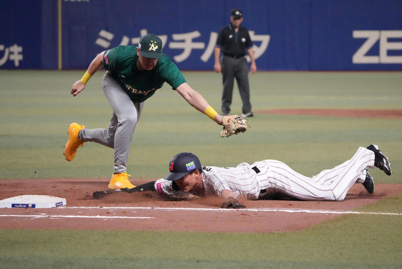 日本対オーストラリア　7回裏日本1死一塁、けん制で飛び出すもタッチを交わし一塁セーフの源田（右）（撮影・森本幸一）