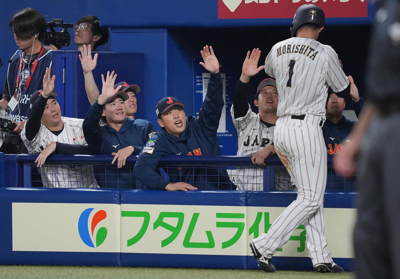 日本対オーストラリア　8回裏日本2死二塁、栗原の適時打で生還した森下（右）を出迎える井上（左から2人目）ら投手陣（撮影・垰建太）
