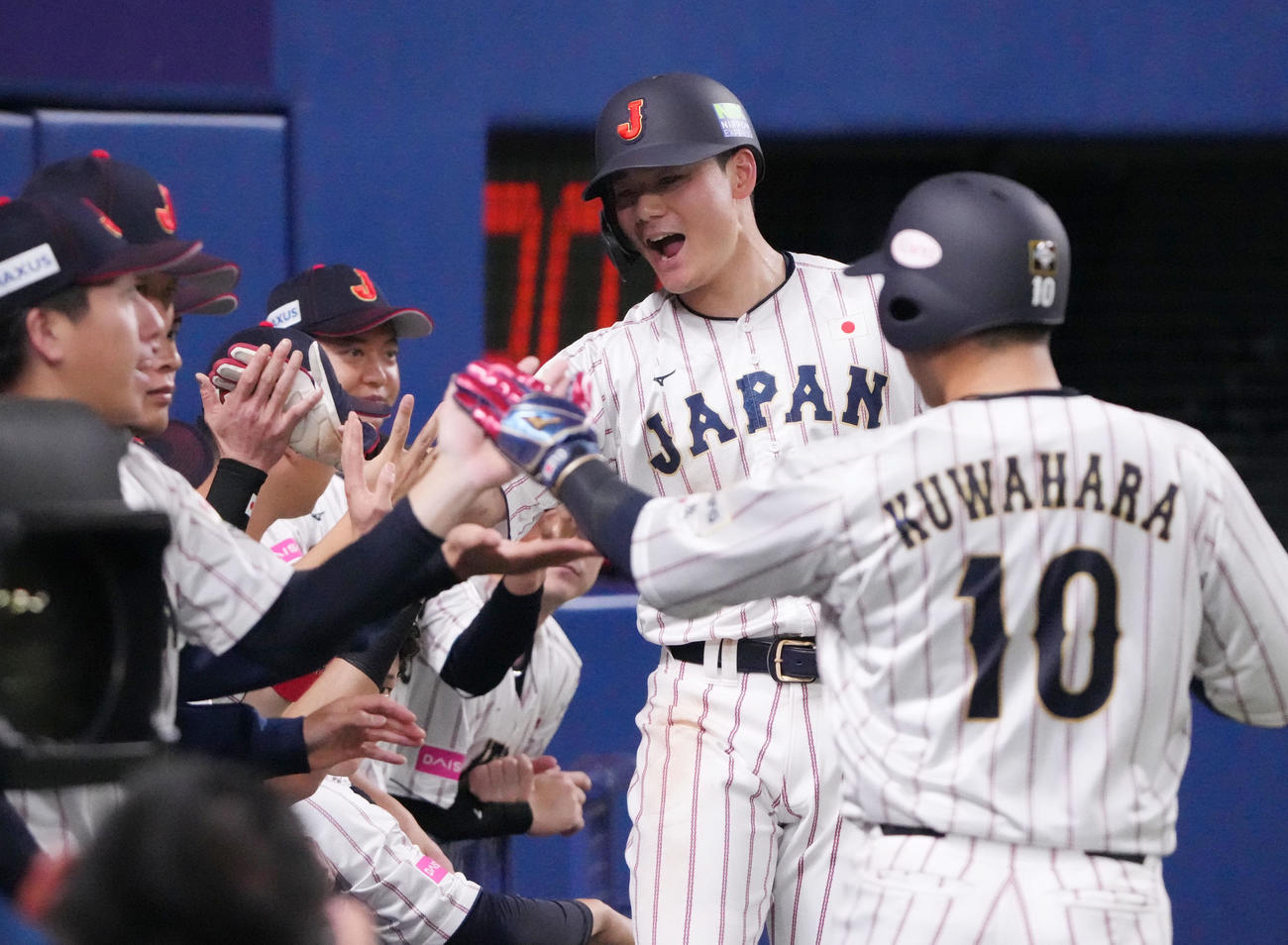 日本対オーストラリア　2回裏日本1死満塁、小園の一ゴロの間に生還しナインとタッチを交わす清宮（右から2人目）（撮影・森本幸一）