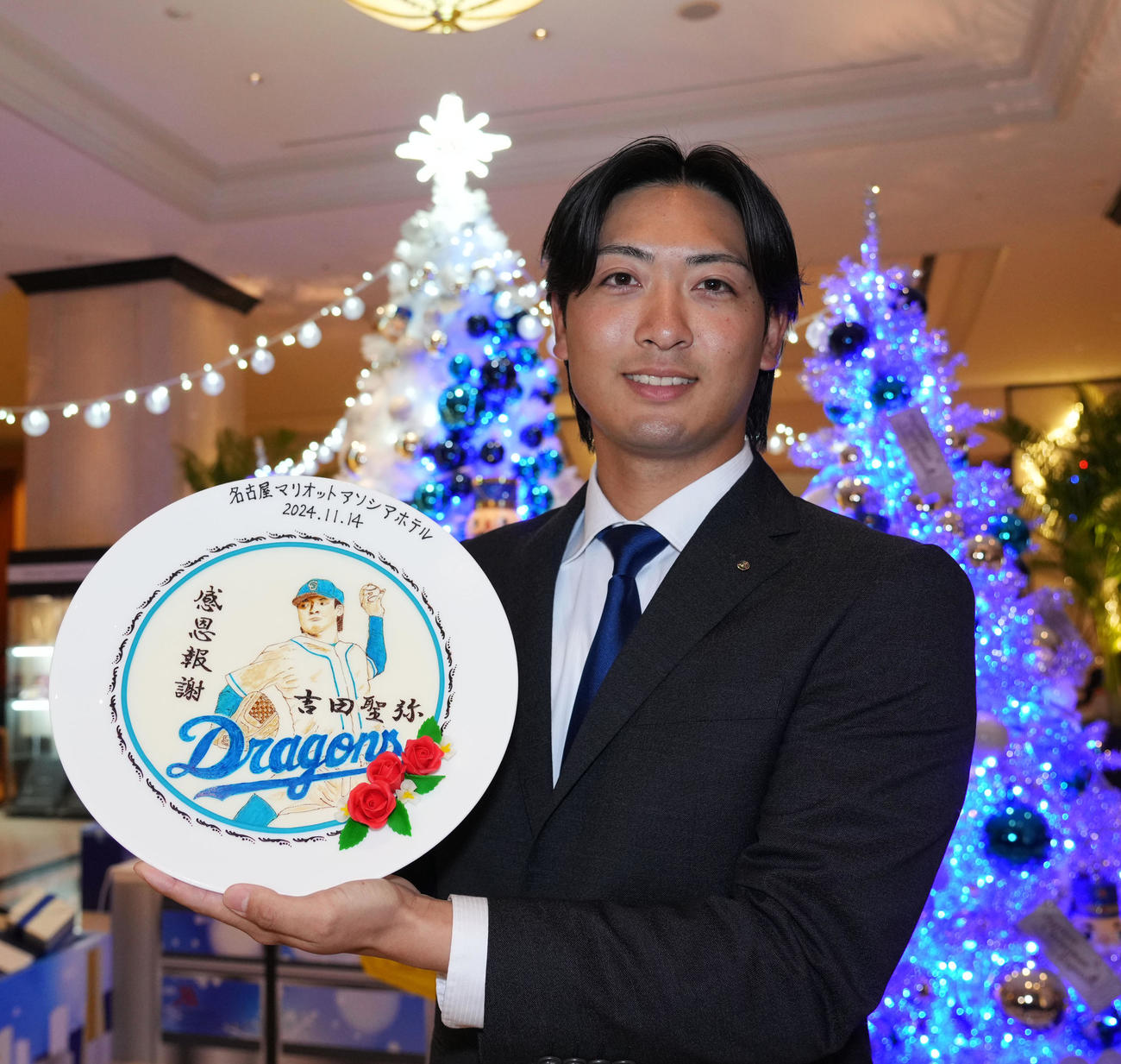 会見場の名古屋マリオットアソシアホテルからプレゼントされた記念絵皿を手に笑顔を見せる吉田（撮影・森本幸一）