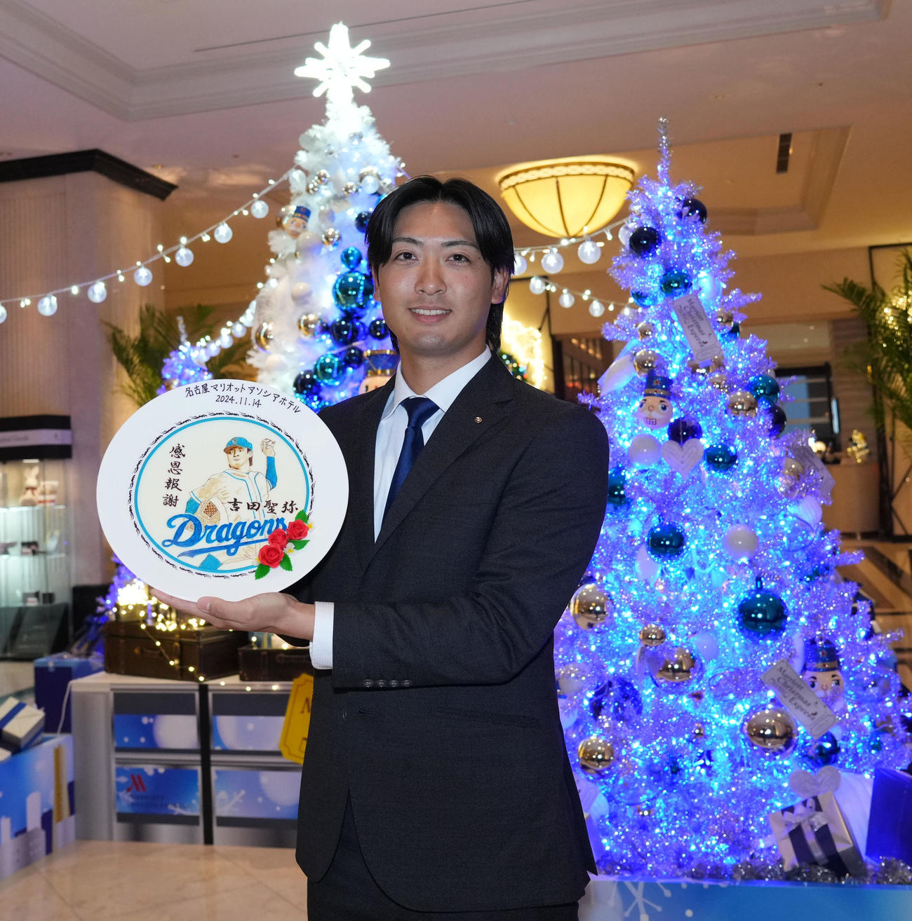 会見場の名古屋マリオットアソシアホテルからプレゼントされた記念絵皿を手に笑顔を見せる吉田（撮影・森本幸一）