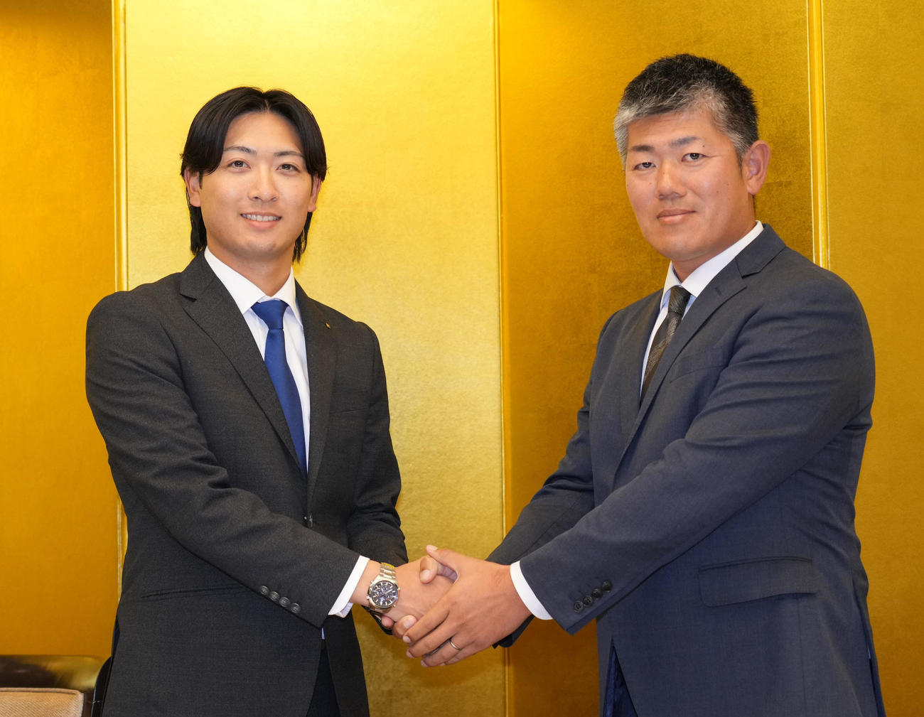 仮契約を済ませ清水スカウトと握手を交わす吉田（左）（撮影・森本幸一）