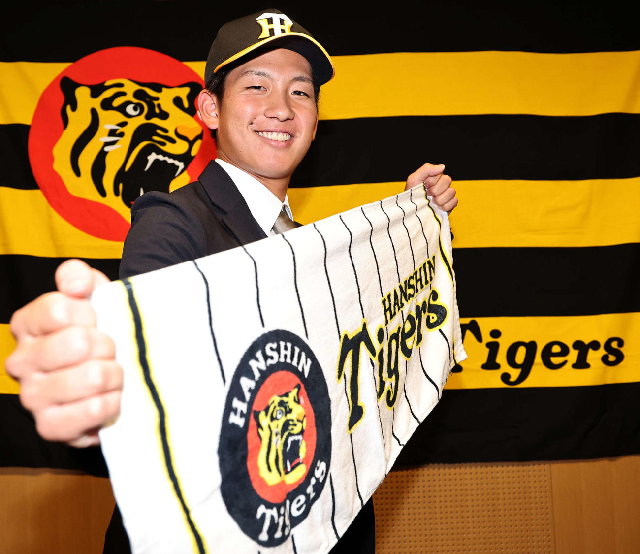 仮契約を終えた阪神ドラフト1位の伊原は笑顔でポーズを決める（撮影・上田博志）