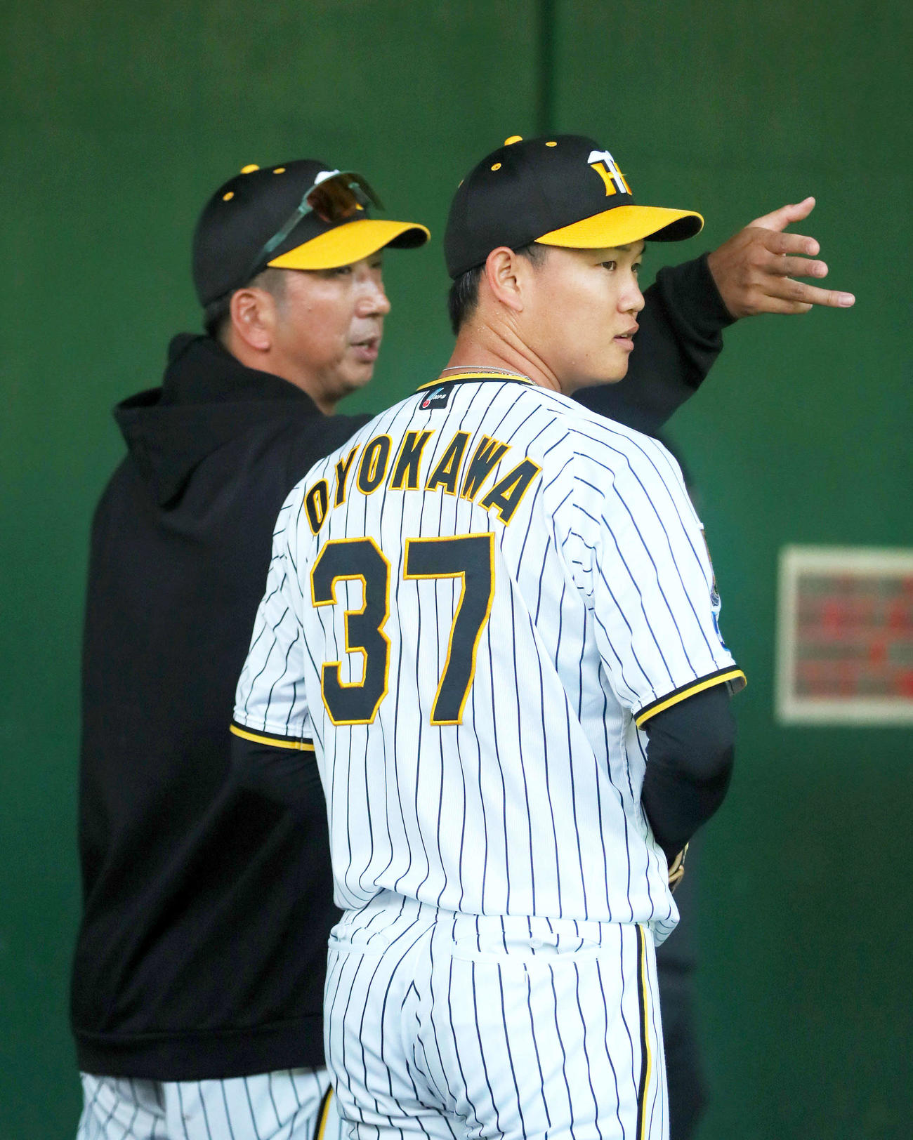 ブルペンで及川（手前）にアドバイスする藤川監督（撮影・上山淳一）