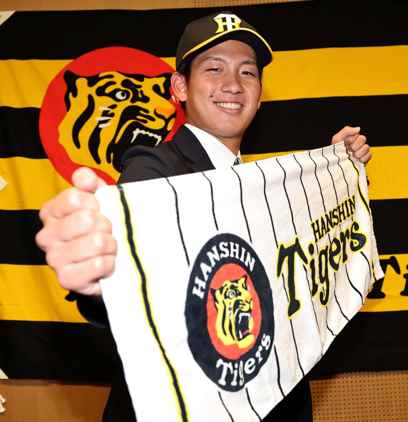 仮契約を終えた阪神ドラフト1位の伊原は笑顔でポーズを決める（撮影・上田博志）