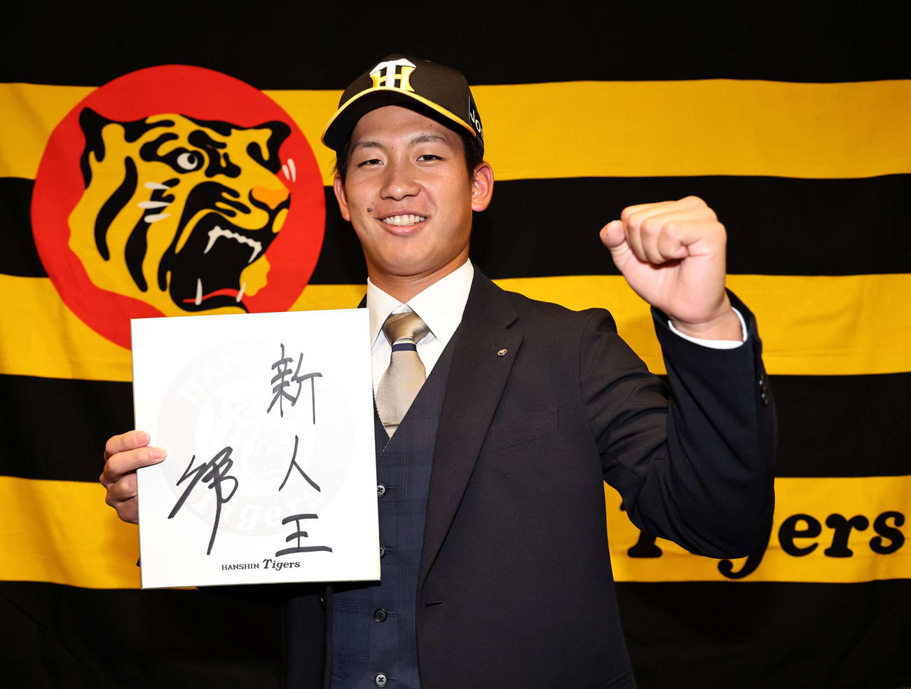 仮契約を終えた阪神ドラフト1位の伊原は目標を書いた色紙を手に笑顔を見せる（撮影・上田博志）