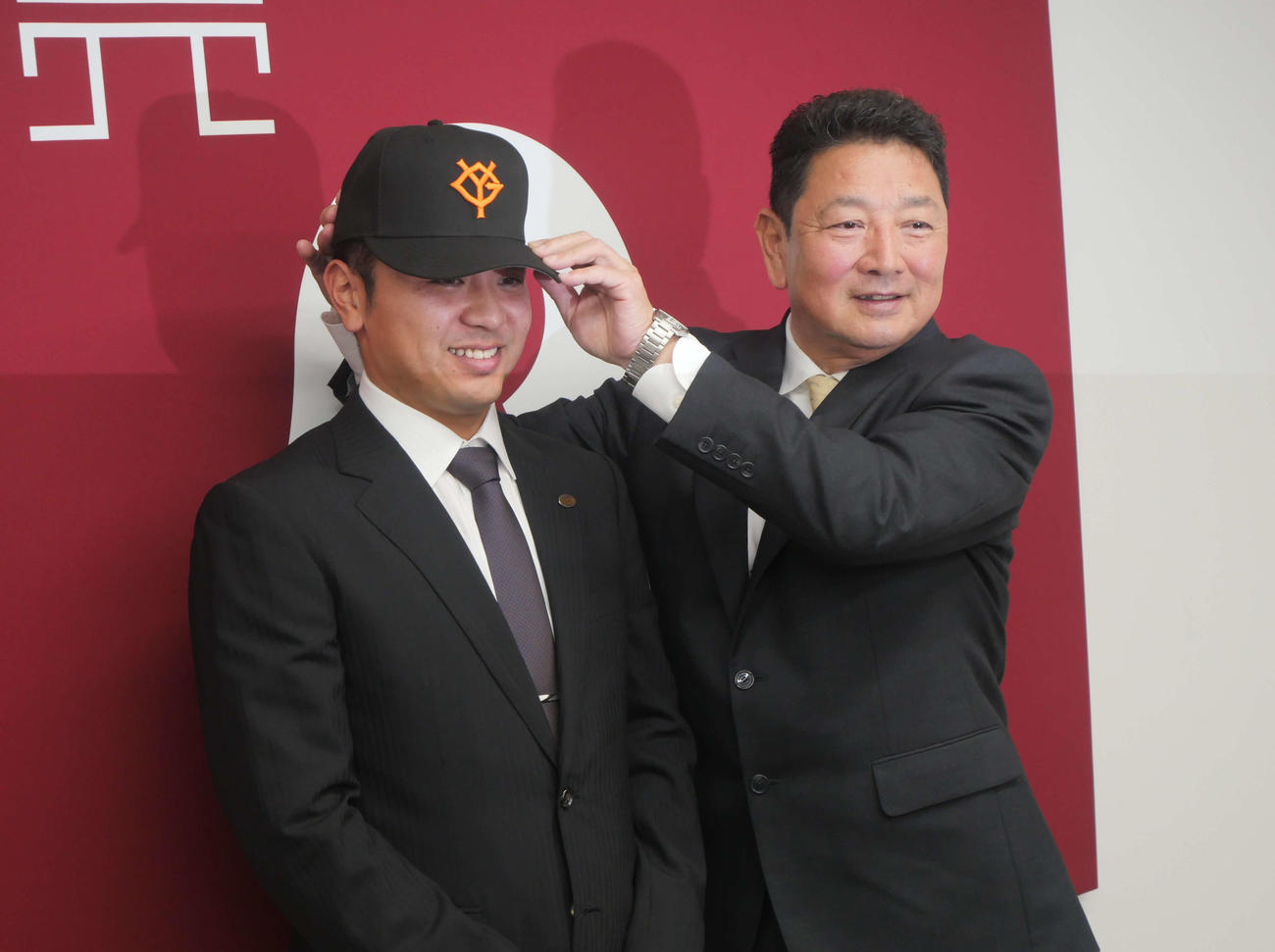 巨人入団会見後、吉村編成本部長から帽子を被せてもらう石川（撮影・上田悠太）