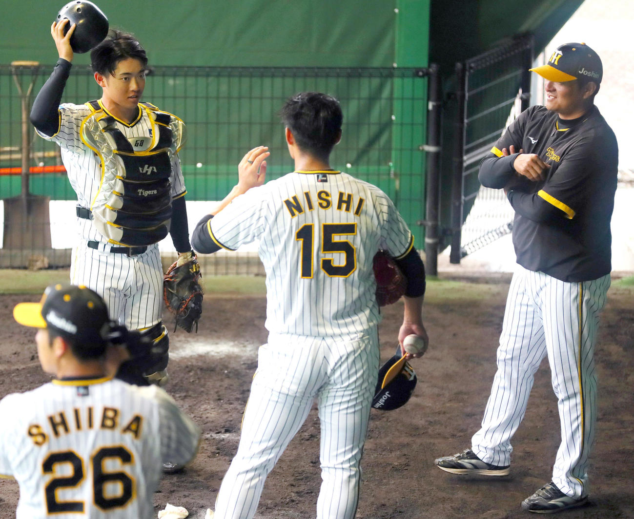 阪神中川（左）はブルペンで投球を終えた阪神西純（右から2人目）と話す。右は久保田2軍投手チーフコーチ（撮影・上山淳一）