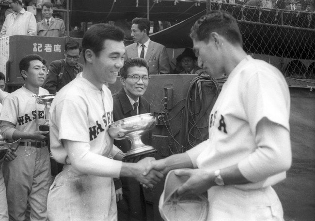 1960年11月12日、早大対慶大　優勝を決め賜杯を胸に石井連蔵監督（右）と握手をする早大・徳武定祐（徳武定之）主将