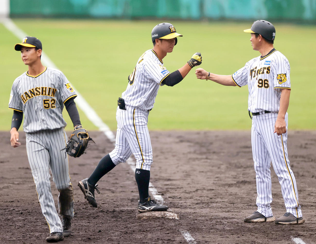紅白戦　5回裏白組2死二、三塁、井坪（中央）は中前適時打を放ち筒井外野守備走塁チーフコーチとタッチをかわす。左は遊撃手山田（撮影・上山淳一）
