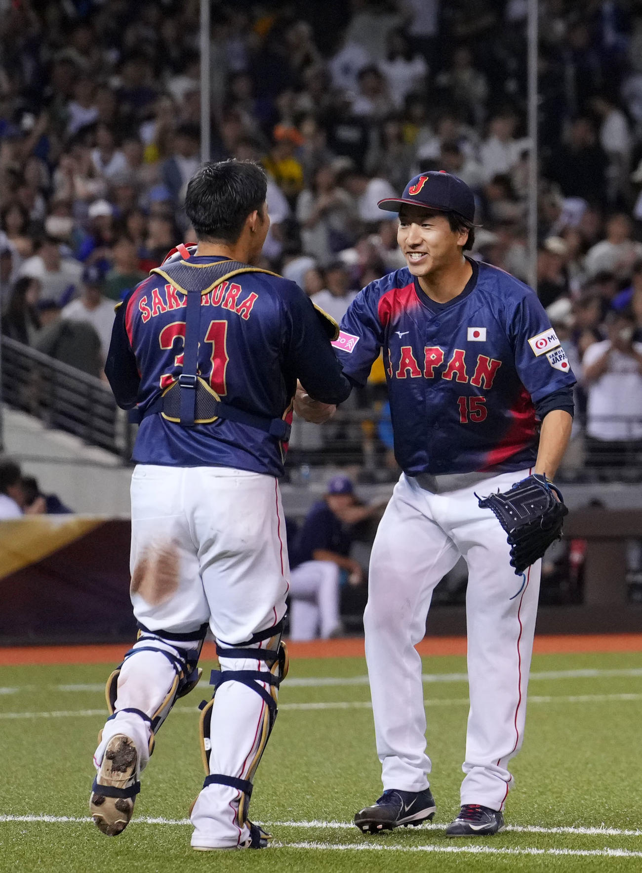 日本対台湾　台湾に勝利し抱き合う大勢（右）と坂倉（撮影・横山健太）