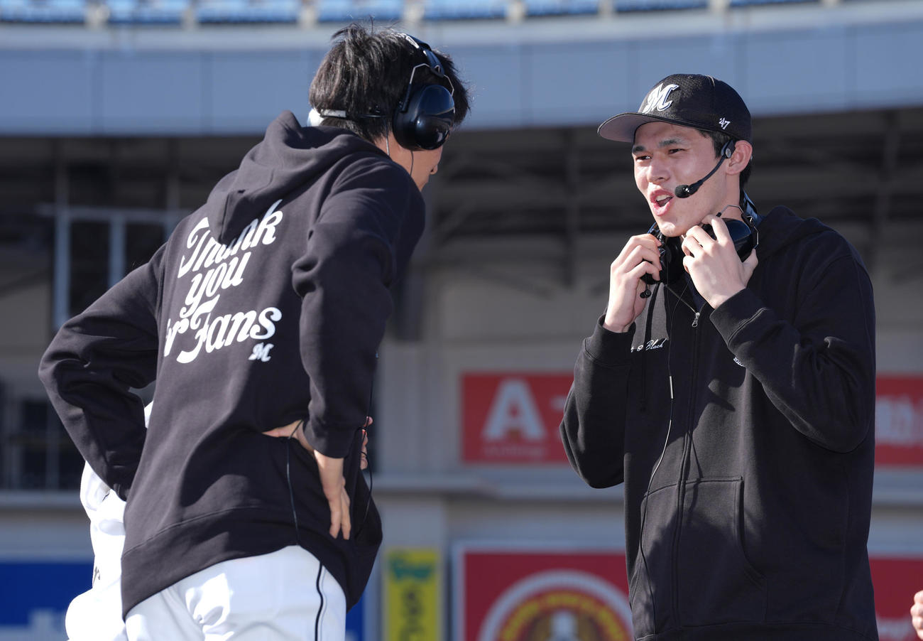 ヘッドホン伝言ゲームで岡（左）に言葉を伝えるロッテ佐々木（撮影・鈴木みどり）