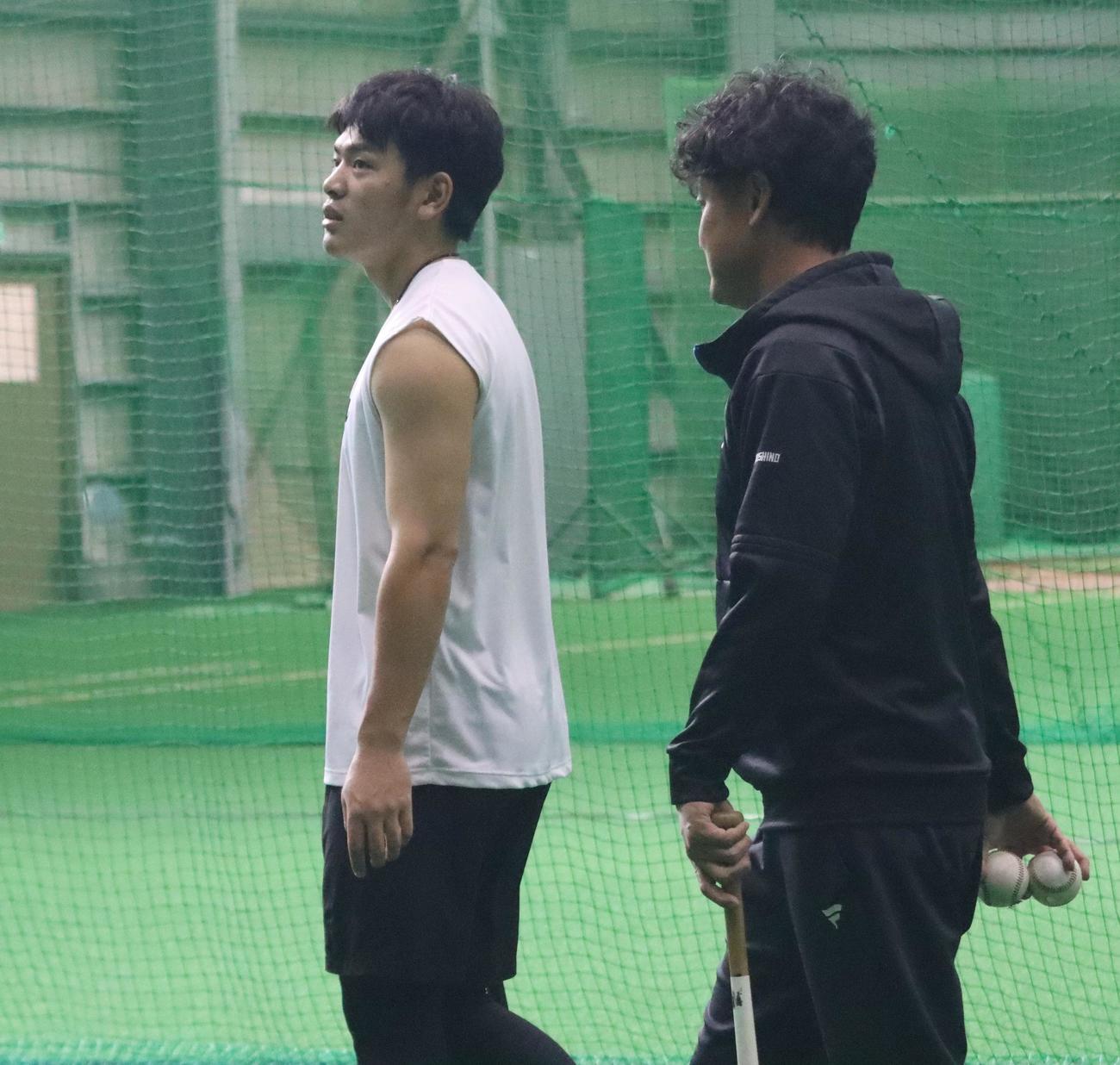 打撃練習の合間に上を見上げる日本ハム野村（左）（撮影・永野高輔）