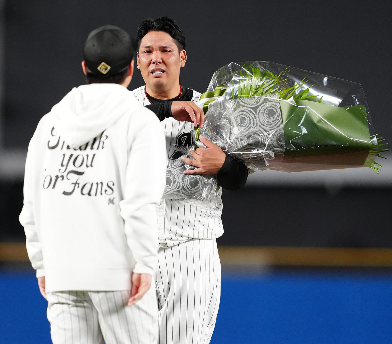 引退セレモニーで美馬（手前）から花束を受け取り、涙するロッテ井上（撮影・鈴木みどり）