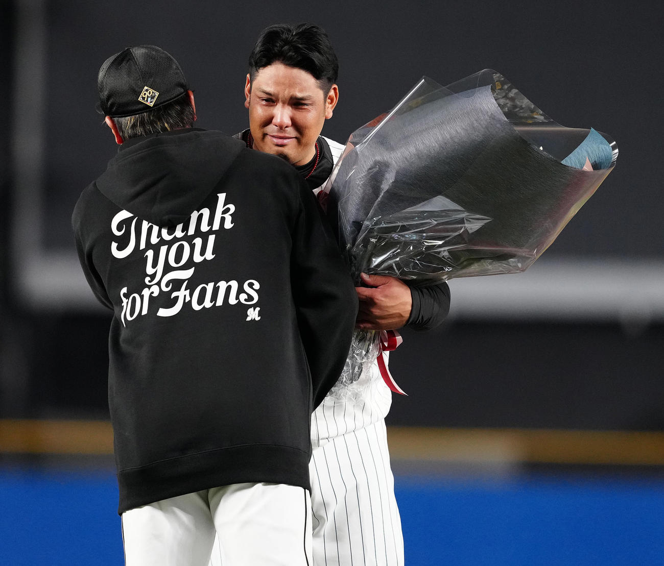 引退セレモニーで益田（手前）から花束を受け取り、涙するロッテ井上（撮影・鈴木みどり）