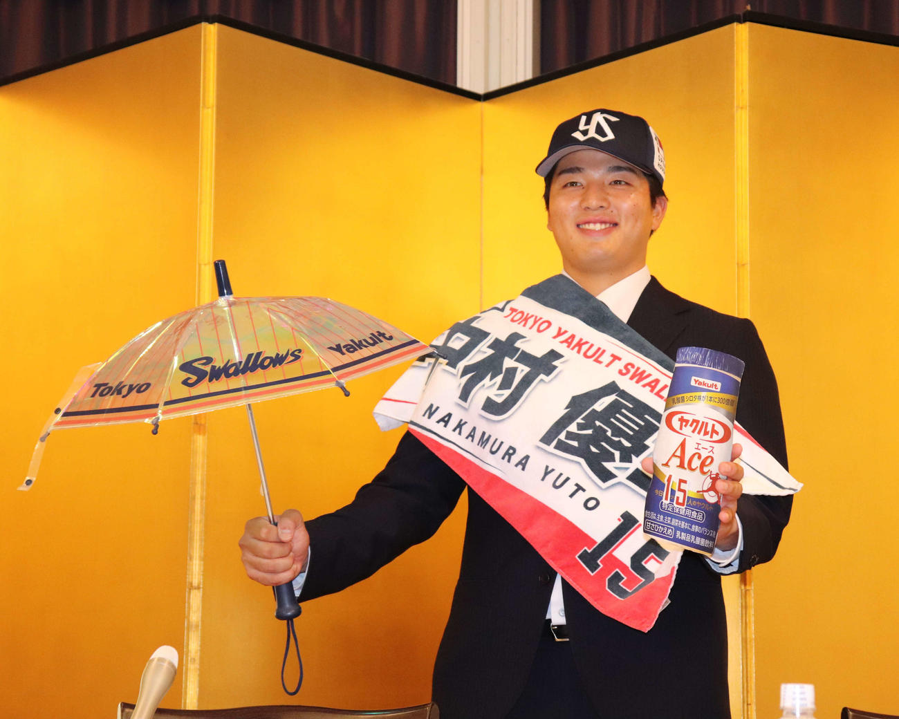 背番号入りのヤクルトAceのボードと応援傘を持つ中村優斗（撮影・中島麗）