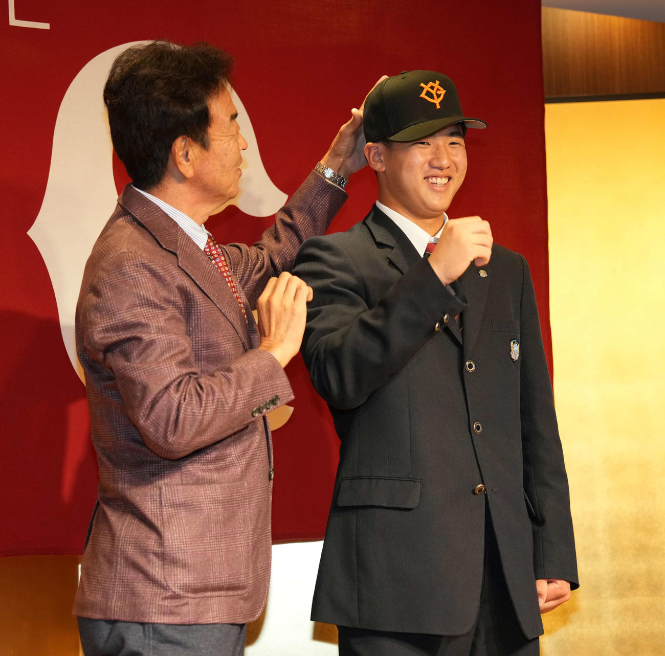 巨人ドラフト1位の花咲徳栄・石塚（右）は水野スカウト部長に曲がって被っていた帽子を直してもらう（撮影・井上学）
