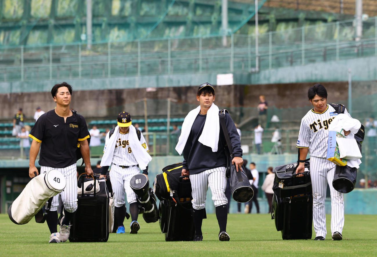 秋季キャンプを打ち上げ、球場を引き揚げる左から阪神井坪、野口、小野寺（撮影・藤尾明華）