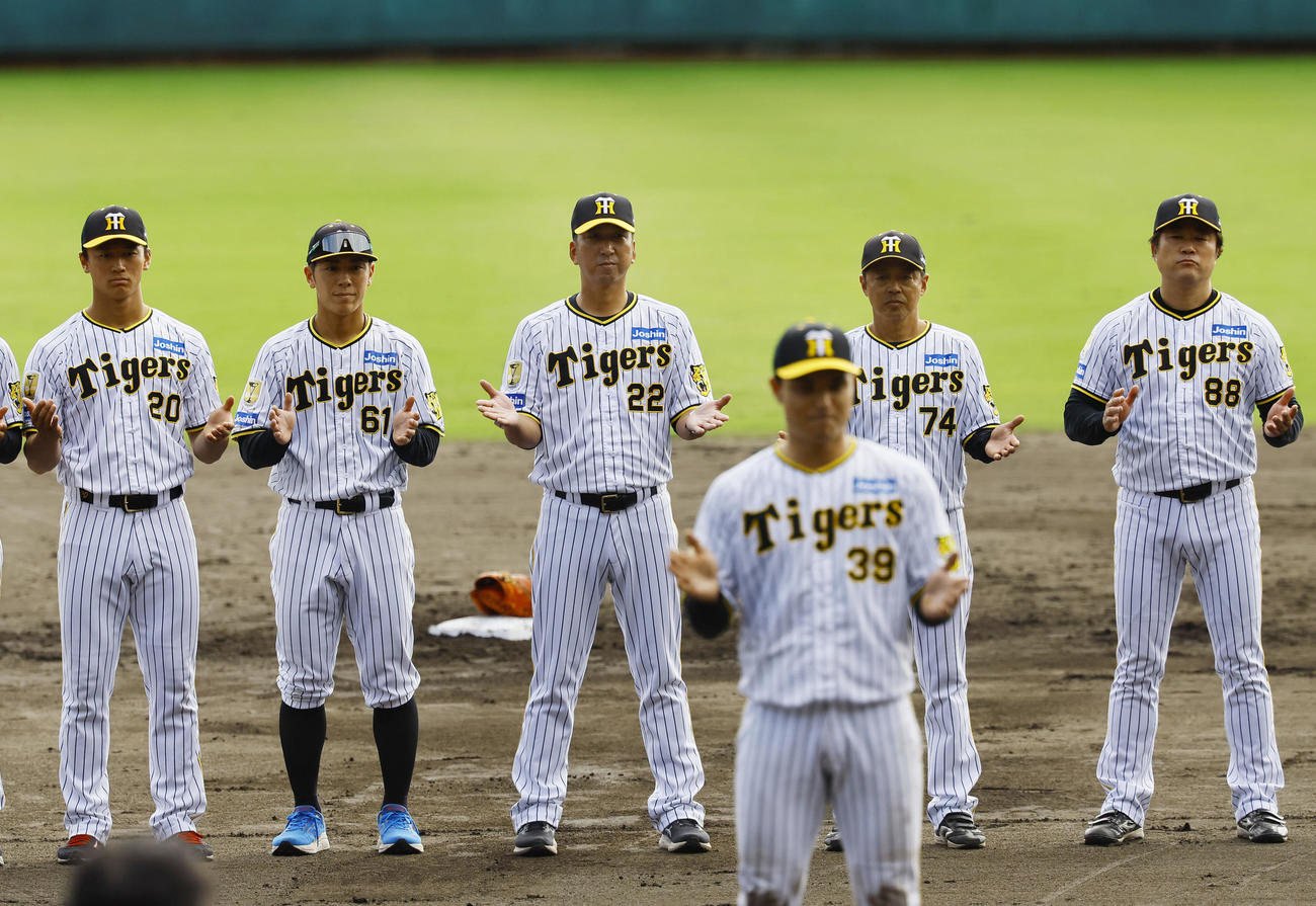 秋季キャンプを打ち上げ、手締めをする（後方左から）森木、豊田、藤川監督、藤本総合コーチ、安藤投手コーチ　（撮影・藤尾明華）