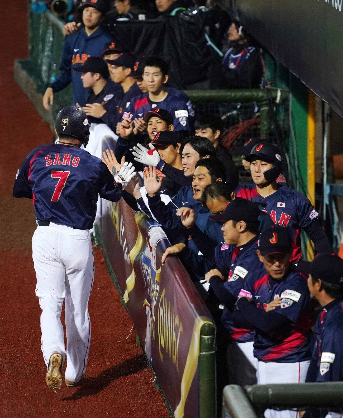 日本対ドミニカ　5回表日本無死一、二塁、栗原の中前適時打で生還した佐野恵太とタッチを交わす日本ナイン（撮影・横山健太）