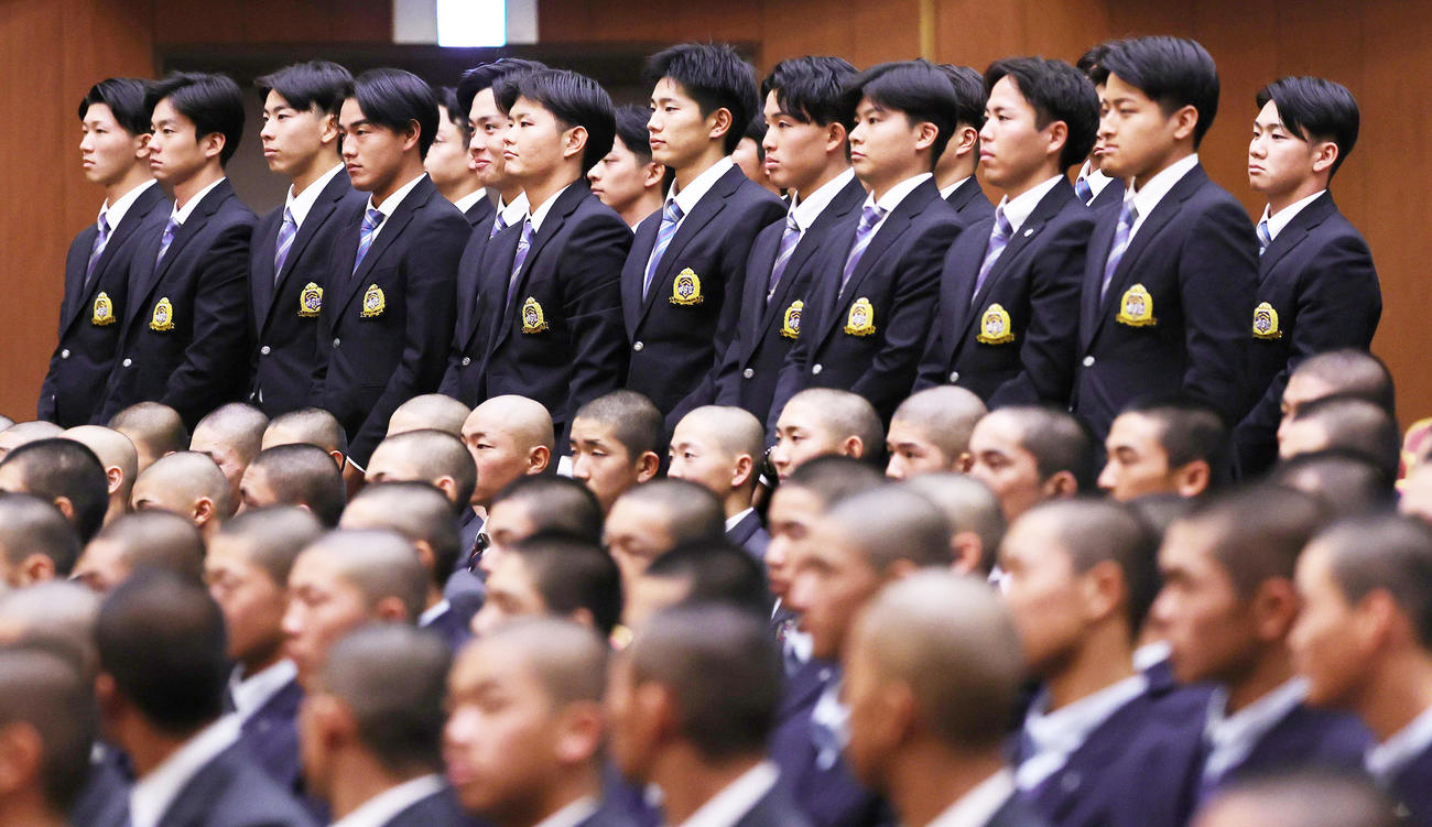 開会式の出場校紹介で、起立する西川（左から4人目）ら青学大の選手たち（撮影・野上伸悟）