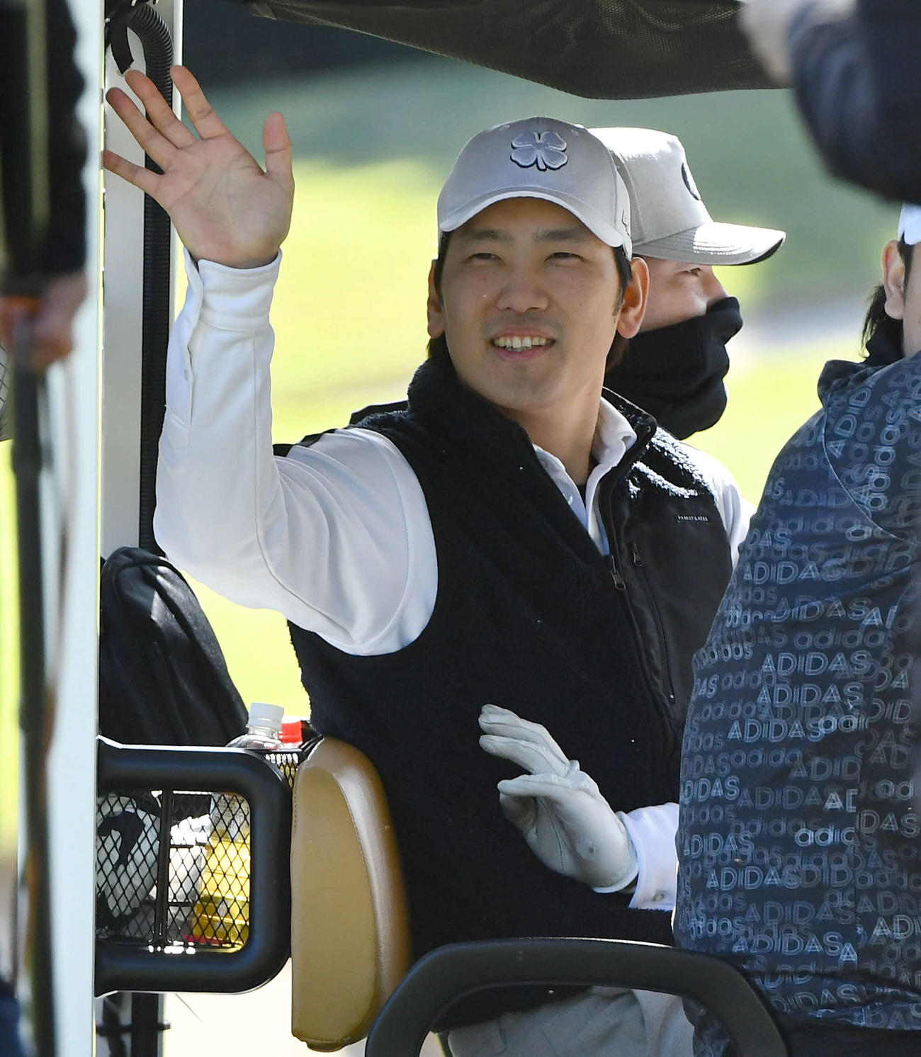 ソフトバンク球団納会ゴルフで、カートから手を振る石川（撮影・岩下翔太）