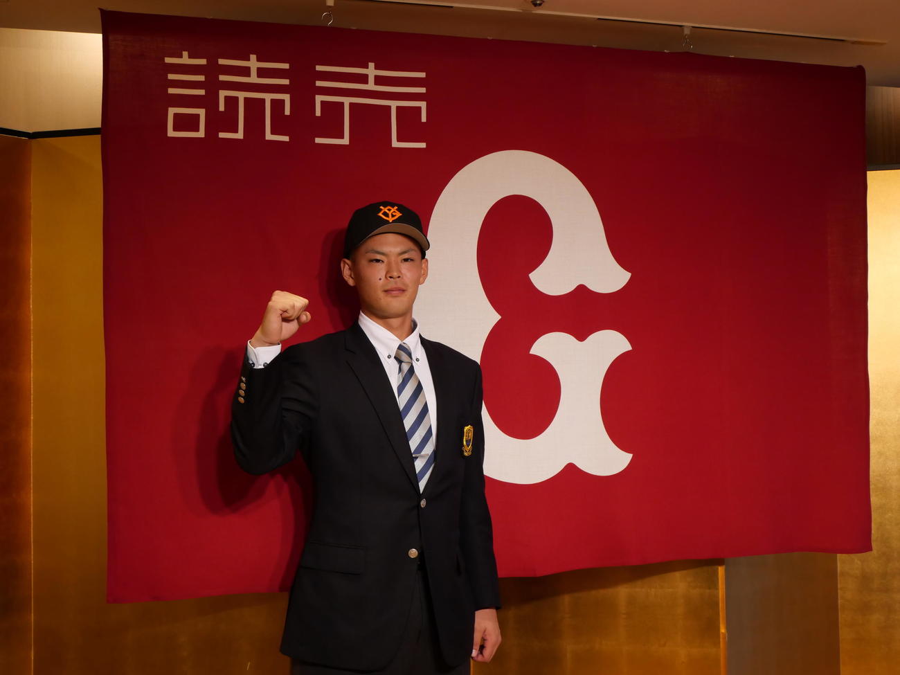 仮契約の会見でガッツポーズをする巨人ドラフト3位の上武大・荒巻（撮影・上田悠太）