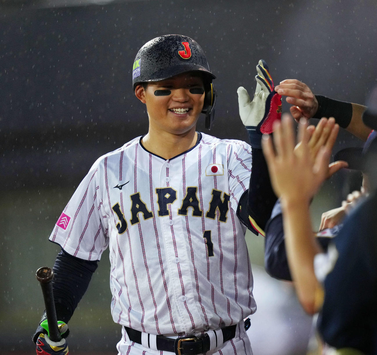 17日、キューバ戦の3回、中犠飛を放ち笑顔でタッチする森下
