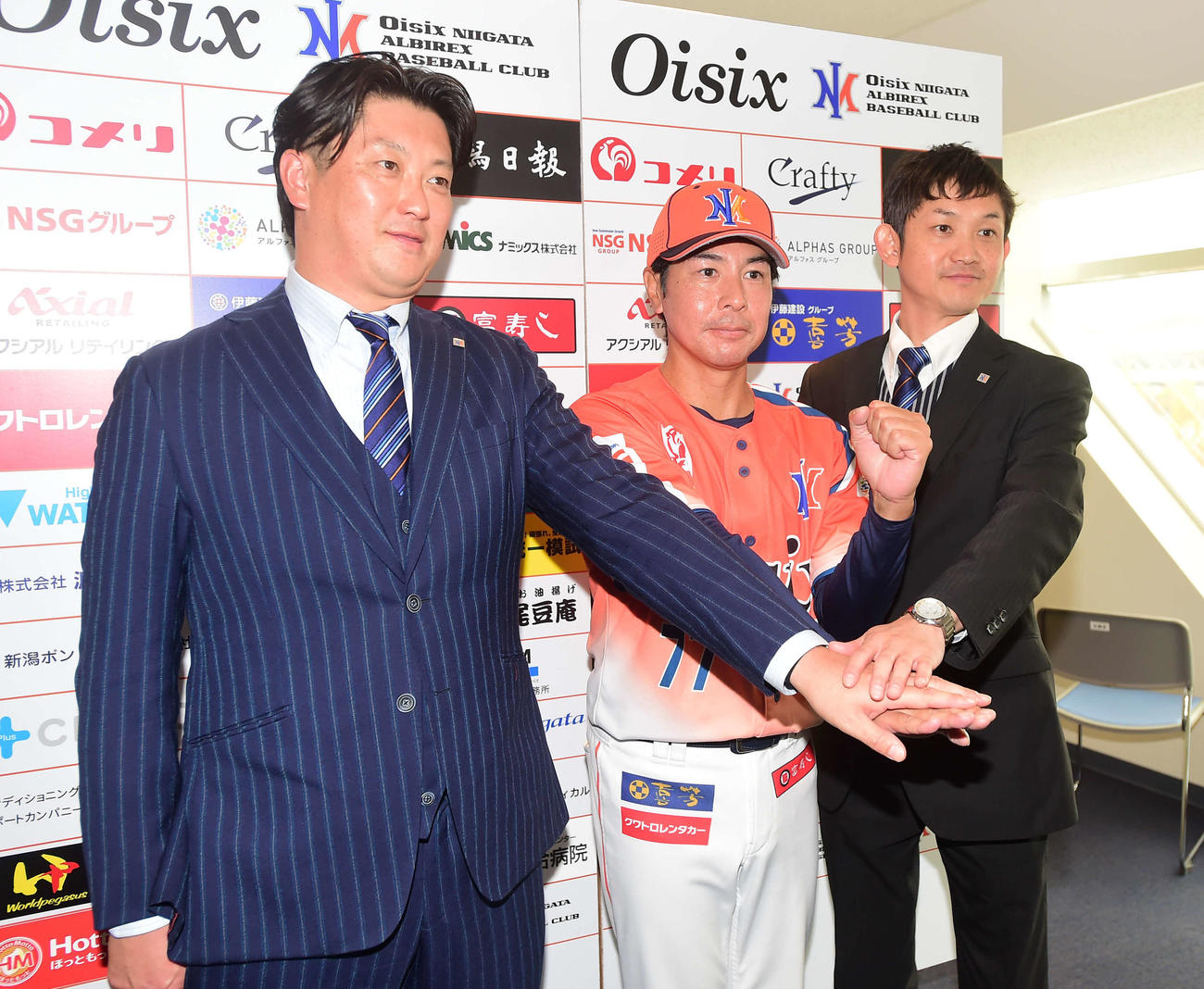 中央で手を合わせる野間口チームディレクター（左）、武田新監督（中央）、池田社長
