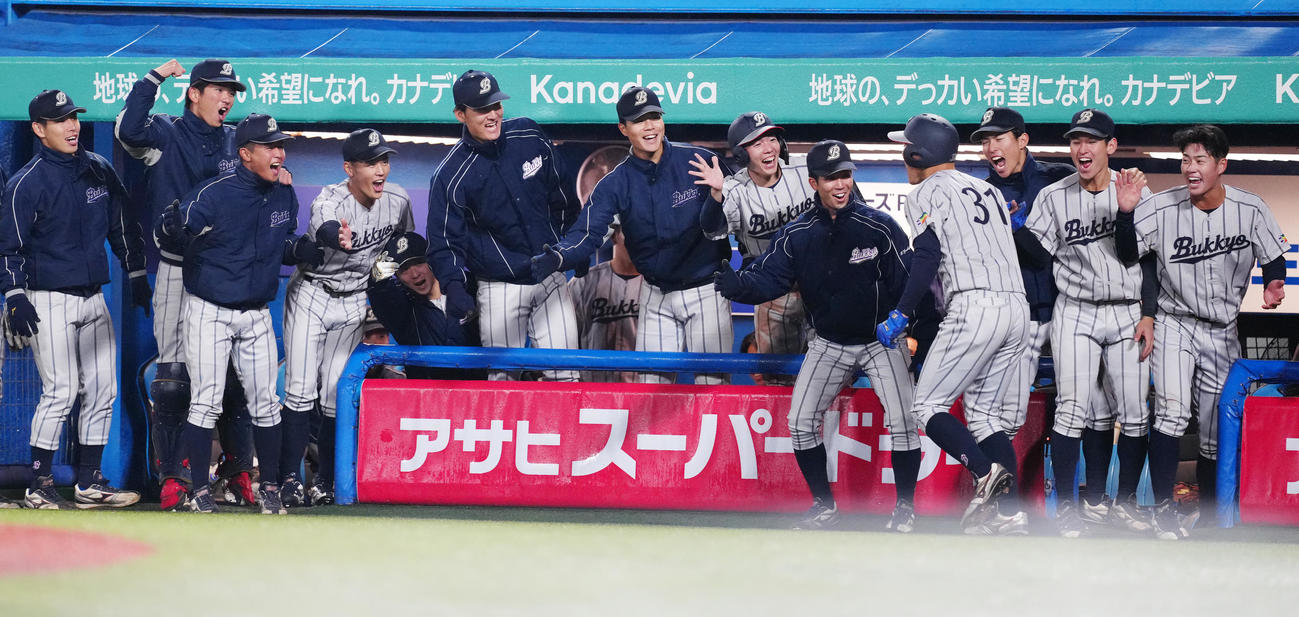 創価大対佛教大　4回裏佛教大1死、ソロ本塁打を放った鳴坂（右から4人目）を迎える選手たち（撮影・江口和貴）