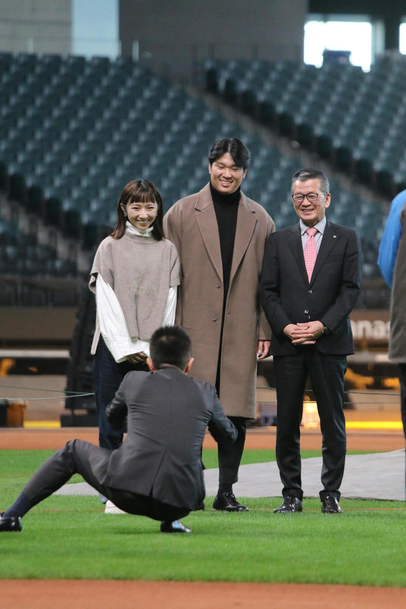 日本ハムの本拠地エスコンフィールドを初訪問し、妻と小村勝球団社長（右）と一緒に記念撮影する古林睿煬投手＝2024年11月21日